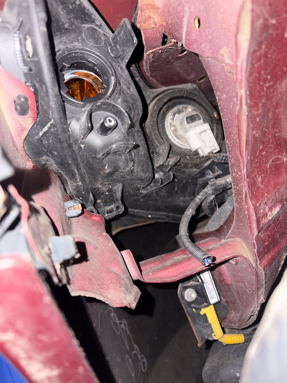 The cut wiring harness and missing bulb socket for the blinker.