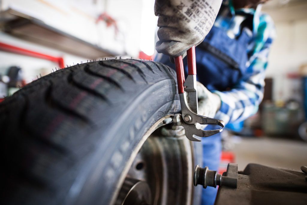 A man is working on a tire in a garage.
