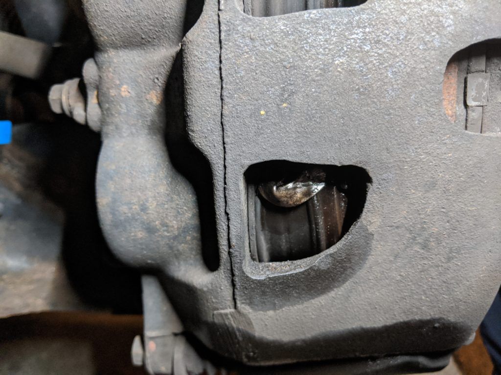 A close up of a brake caliper on a car.
