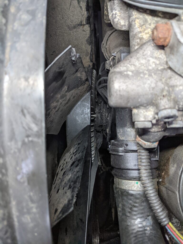 A close up of a fan on a car engine.