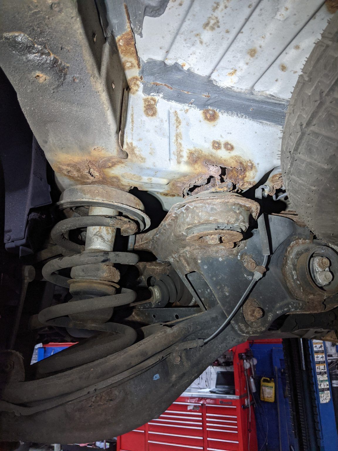 A close up of the underside of a car with rust on it