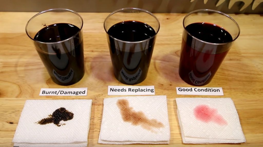 Three glasses of red liquid are sitting on a wooden table