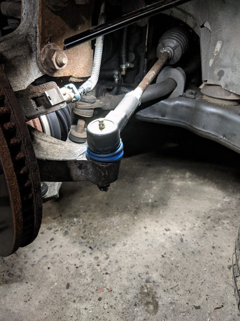 A close up of a tie rod on a car.