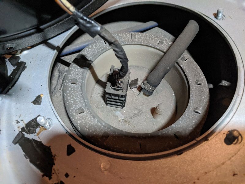 A close up of a gas tank with a hose coming out of it.