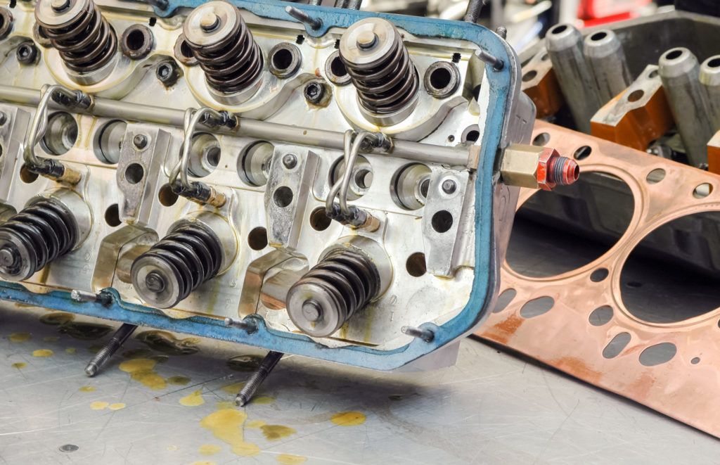 A close up of a car engine head on a table.