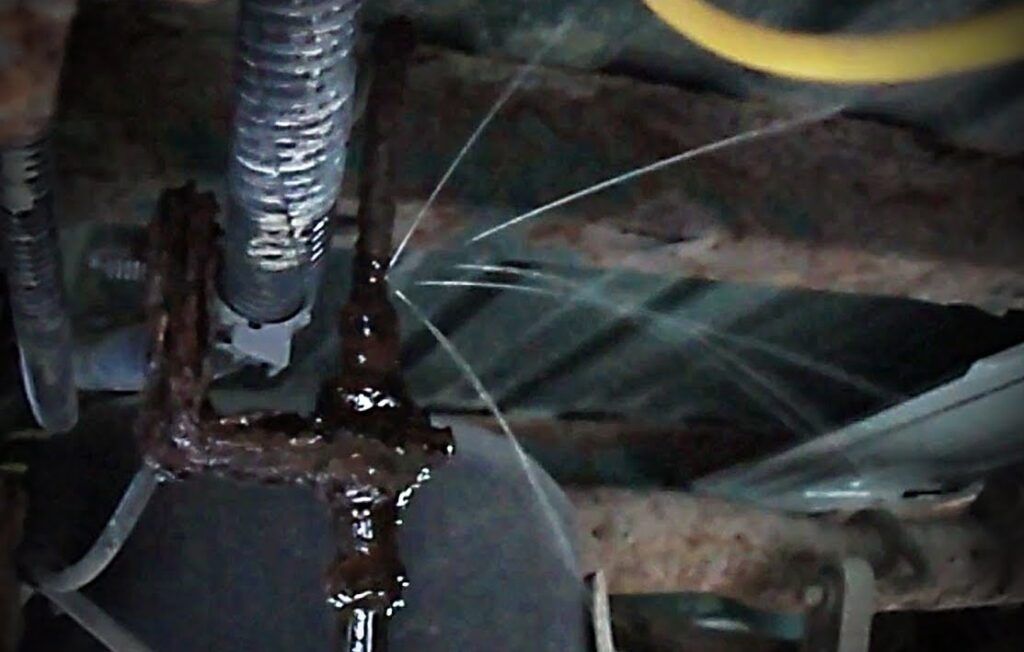 A close up of a rusty pipe with water coming out of it
