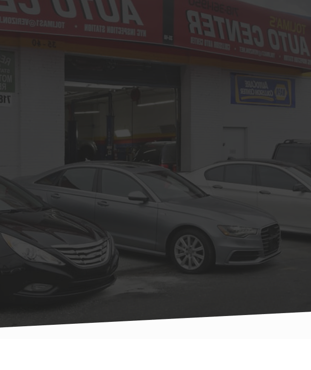 Several cars are parked in front of a car dealership