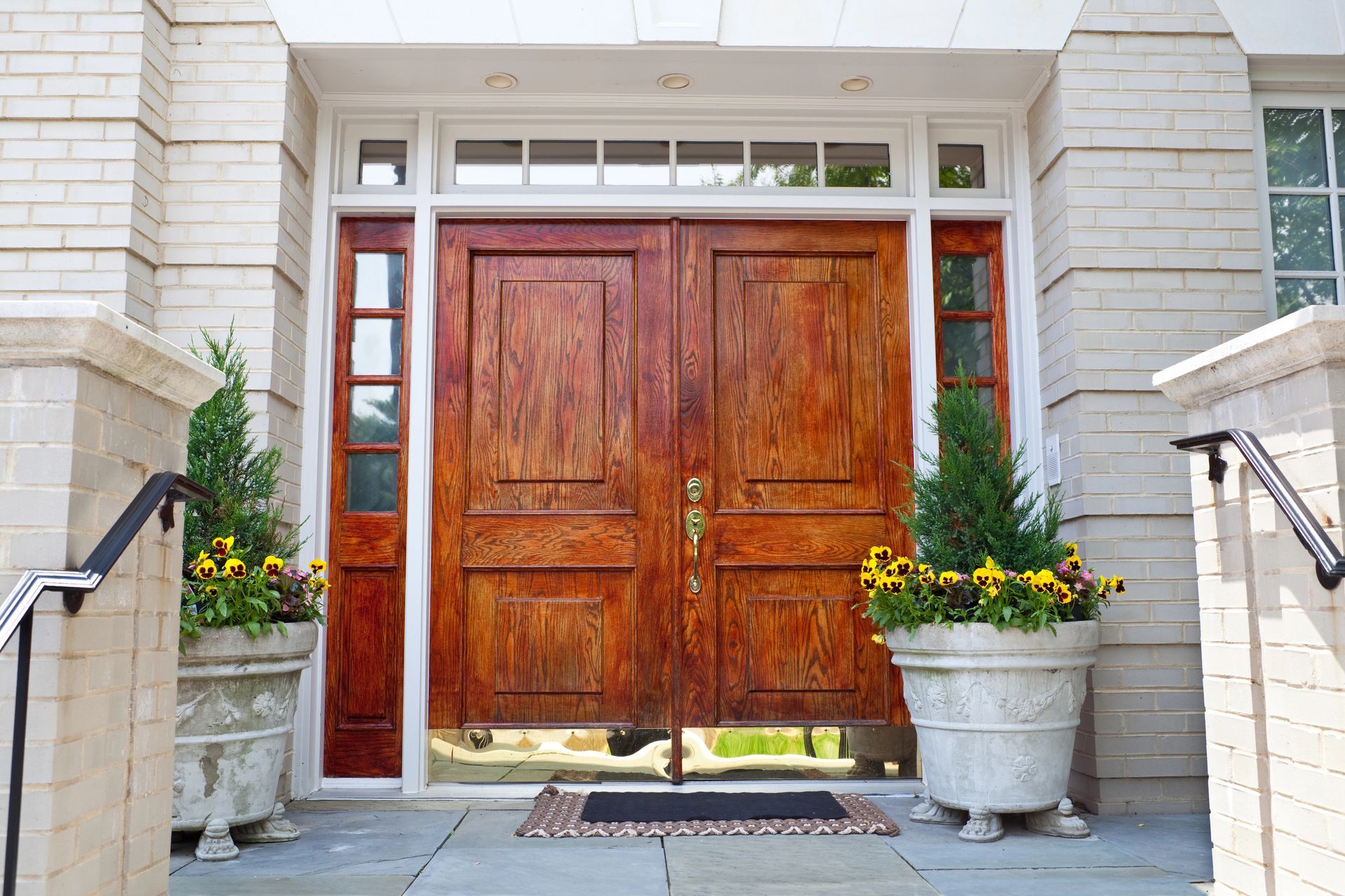 A large wooden door with flowers in pots in front of it