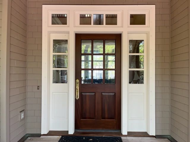 A large wooden door with flowers in pots in front of it