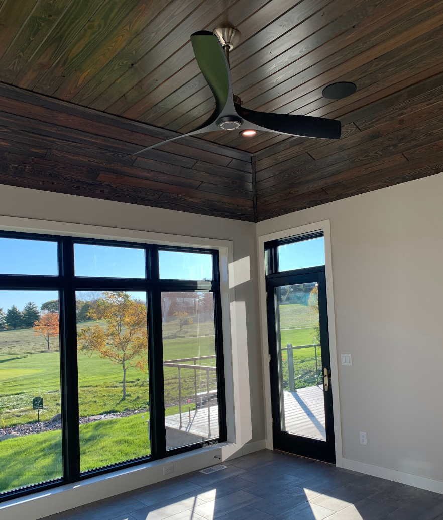 A room with a lot of windows and a ceiling fan