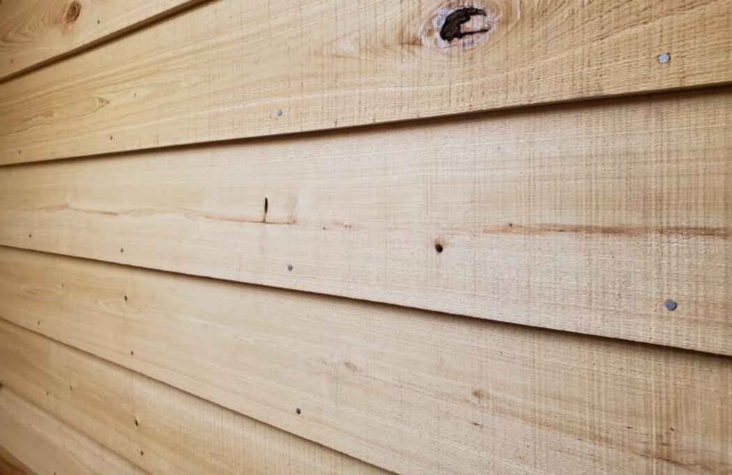 A close up of a wooden siding on a house.