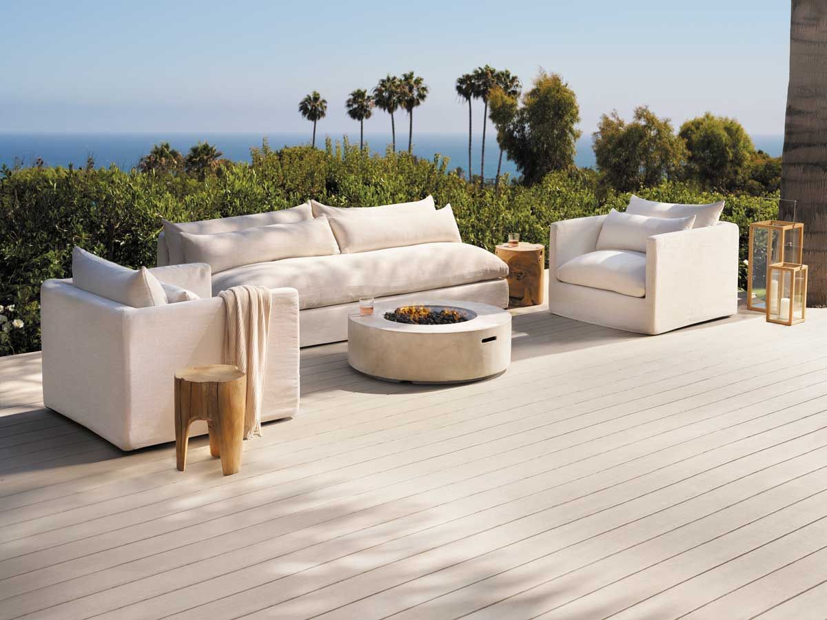 A patio with white furniture and a fire pit