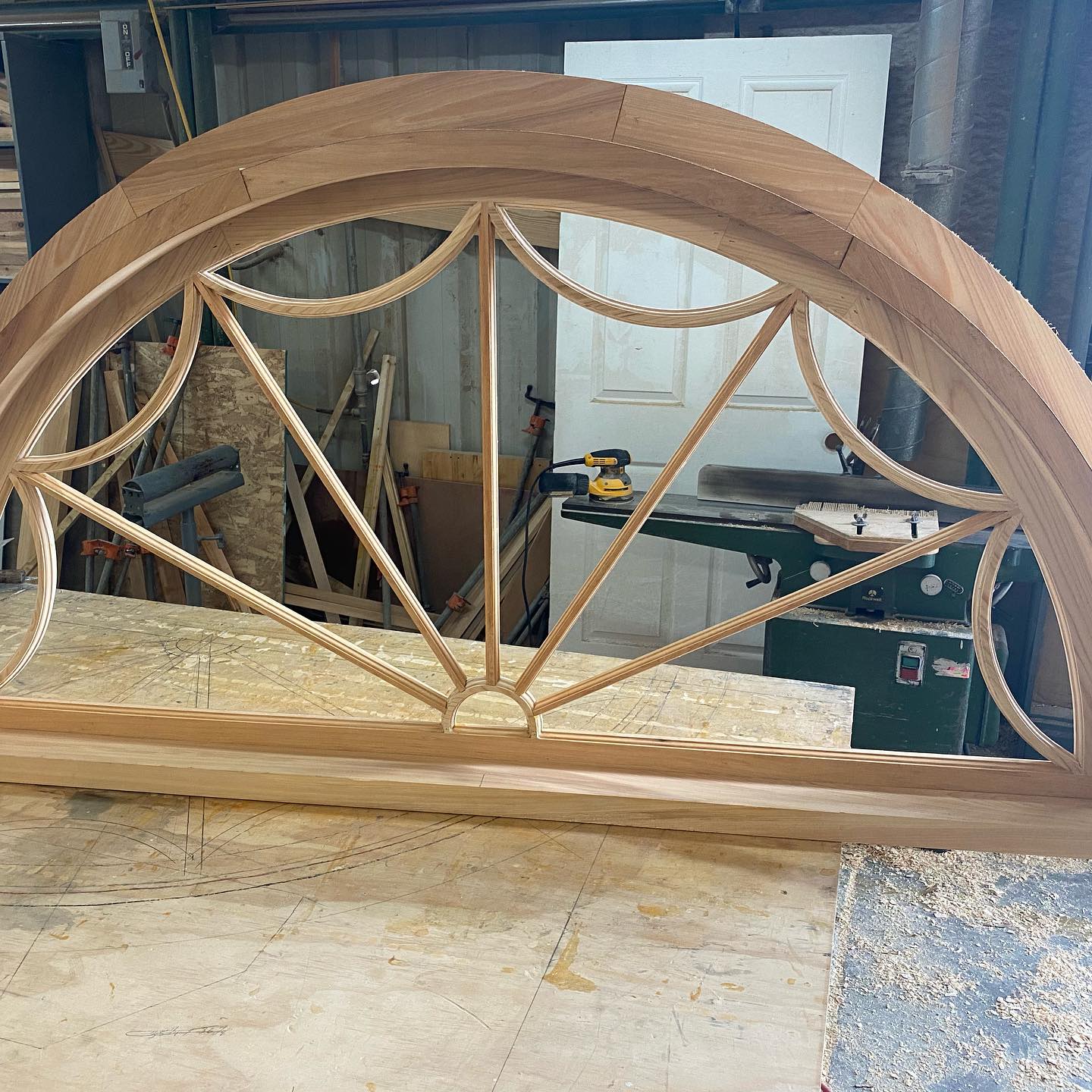 A wooden arch is sitting on a table in a workshop.
