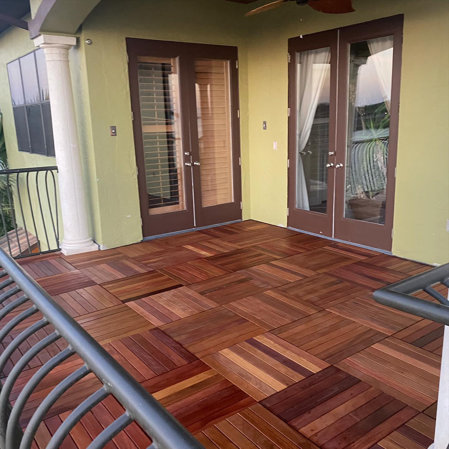 A balcony with a wooden floor and sliding glass doors