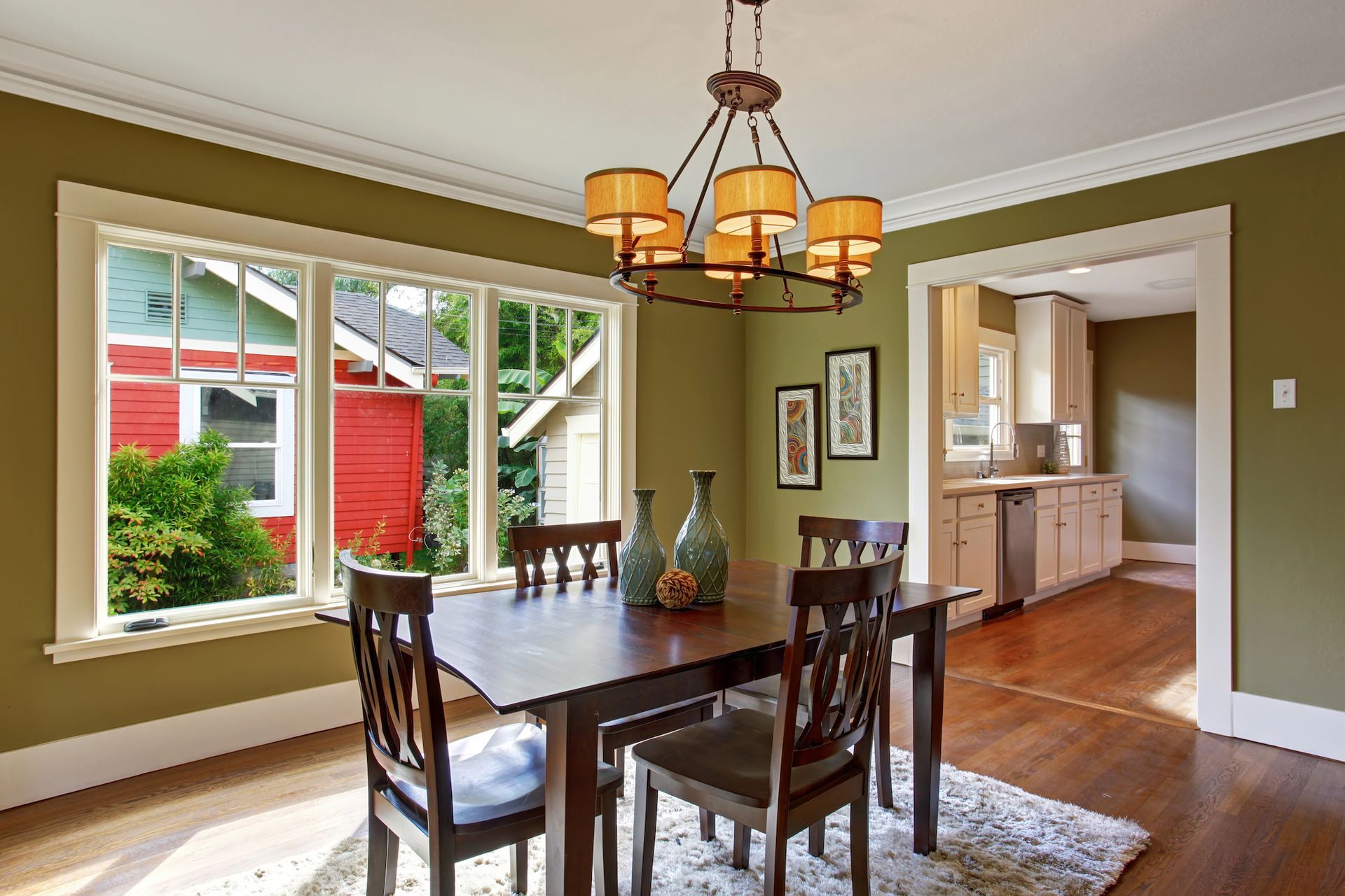 A dining room with a table and chairs and a chandelier hanging from the ceiling.