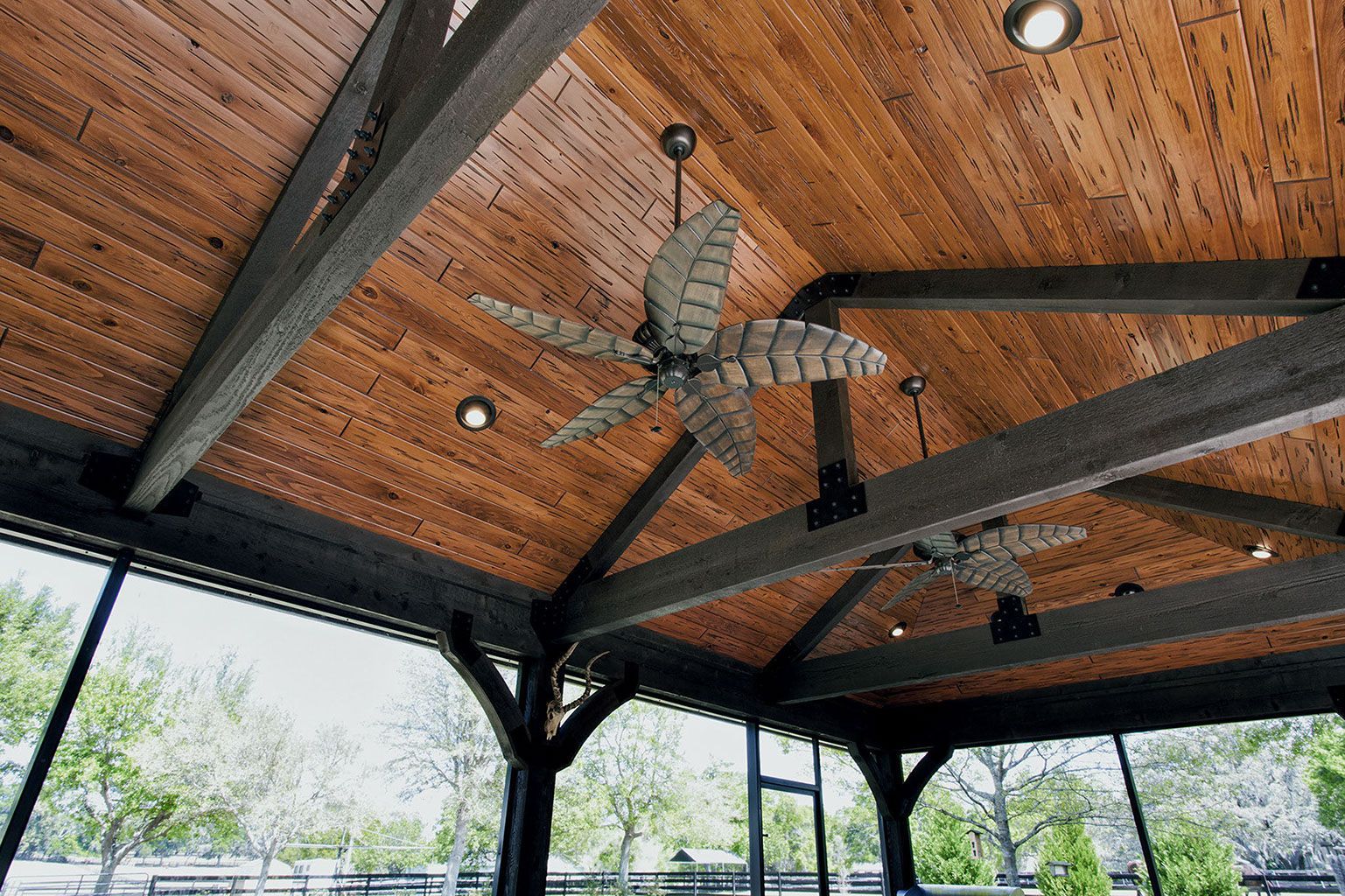 A ceiling fan is hanging from the ceiling of a gazebo.