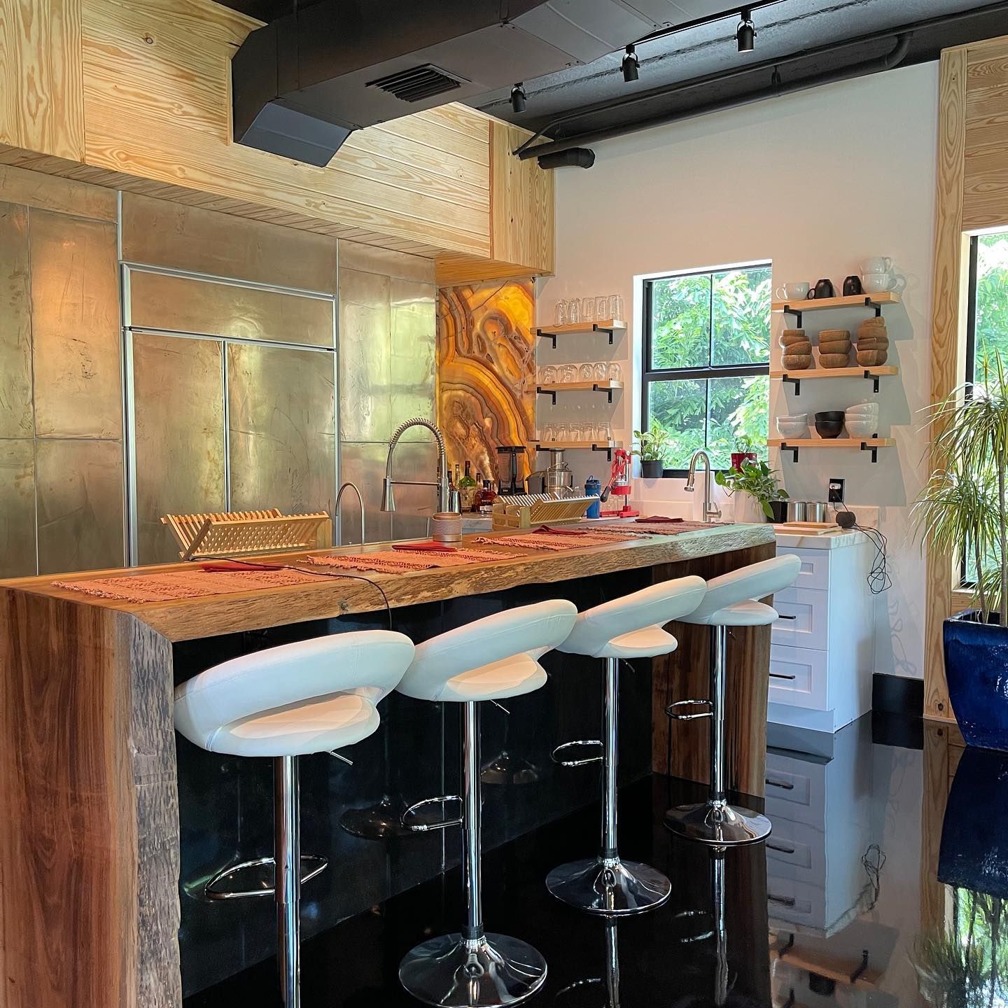 A kitchen with a long counter and stools