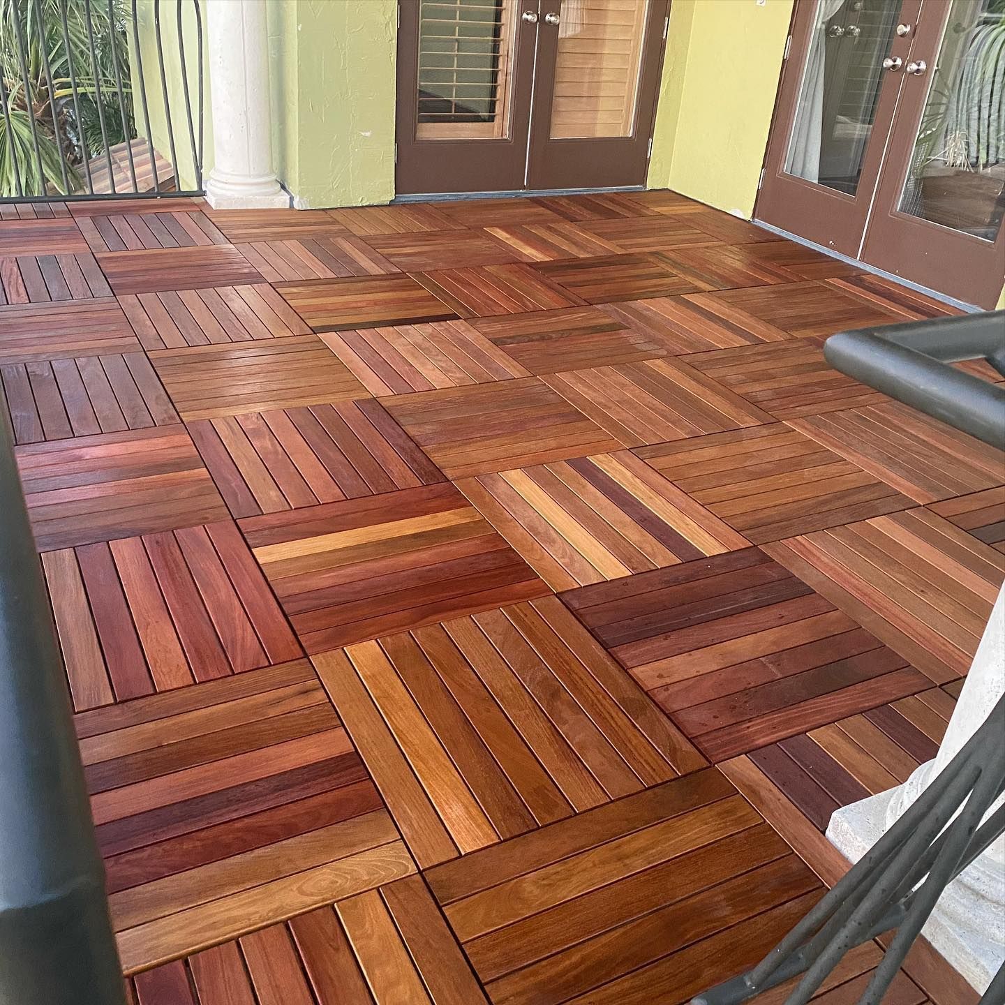 A balcony with a wooden floor and sliding glass doors