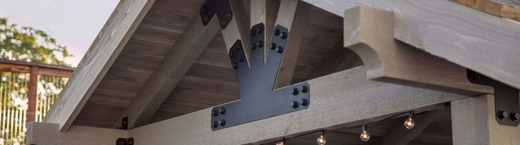 Wooden patio roof with metal support brackets.