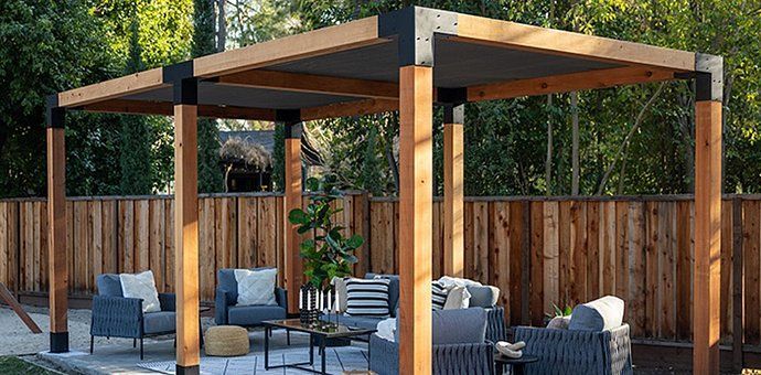 Wooden pergola over outdoor seating area with neutral-colored cushions.