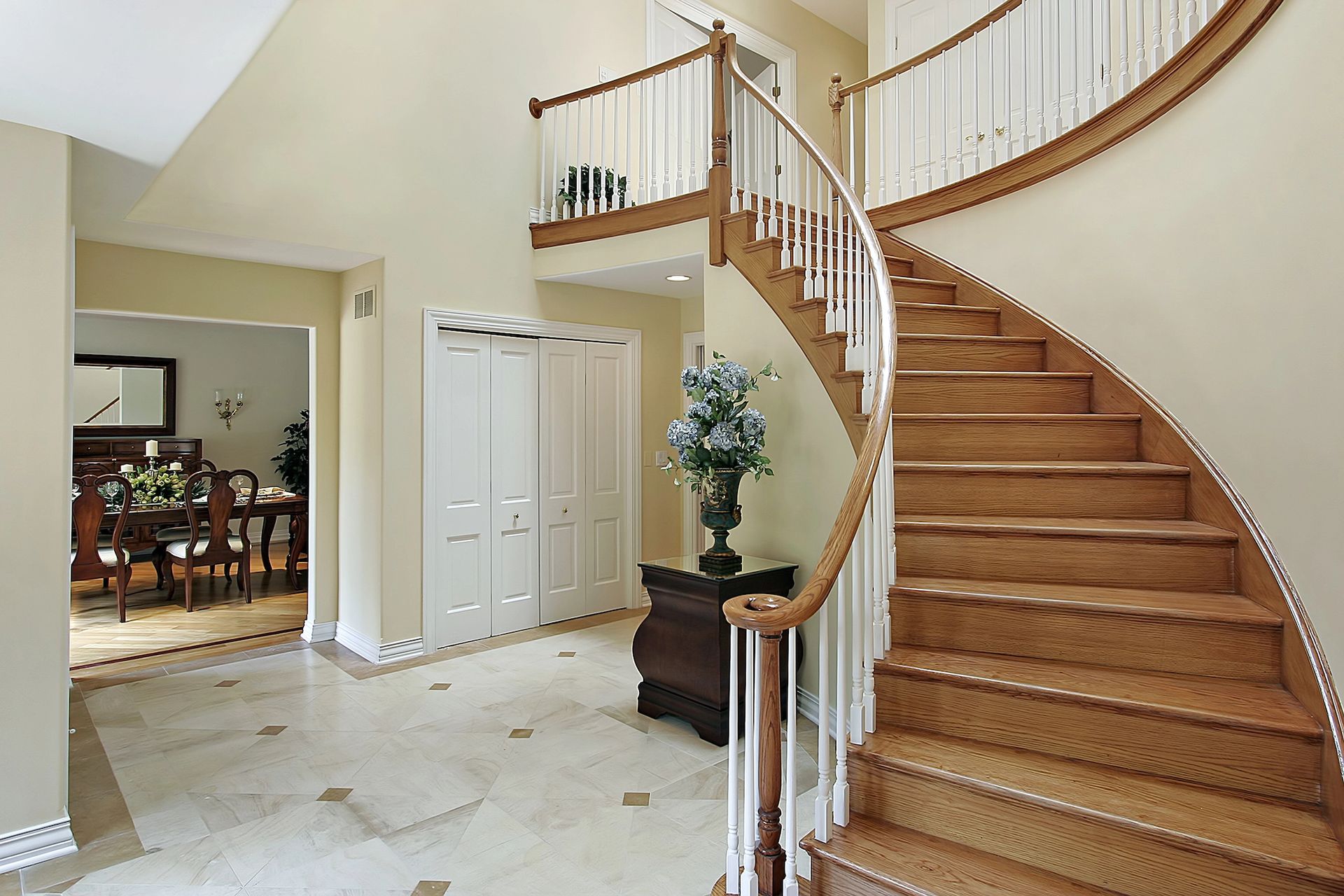 A wooden spiral staircase in a house with a white railing