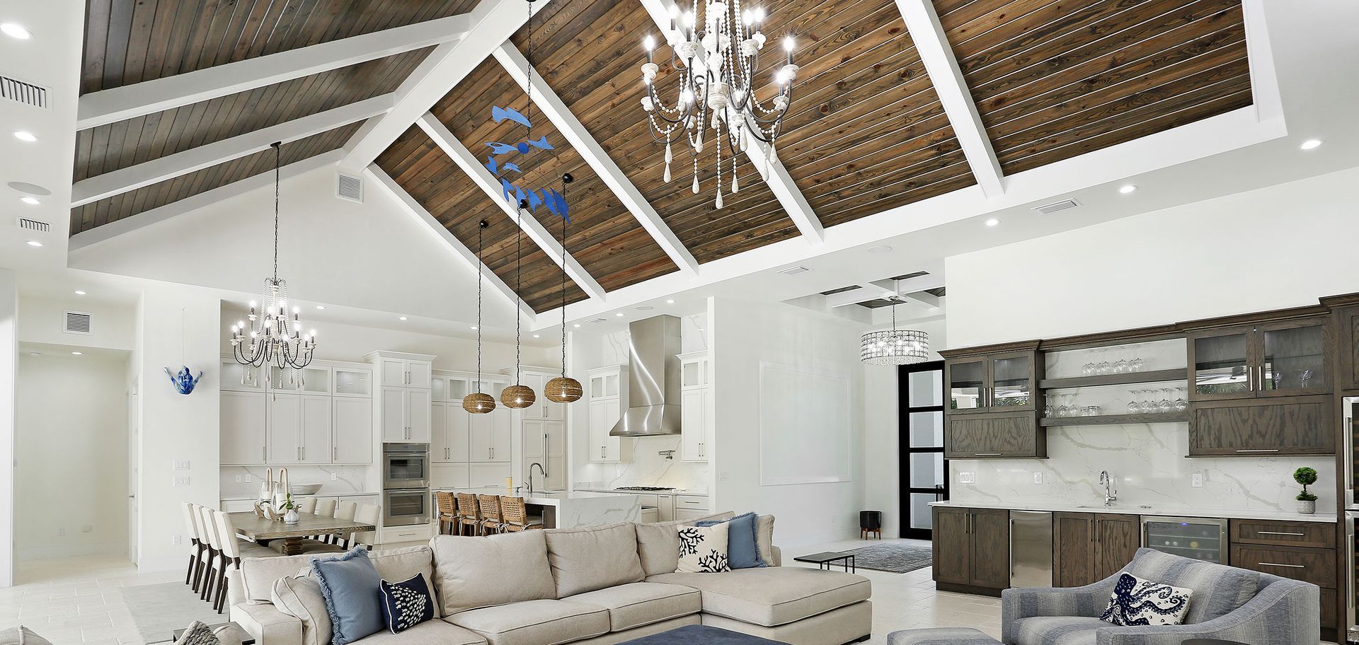 A living room with a couch , chairs , and a chandelier.
