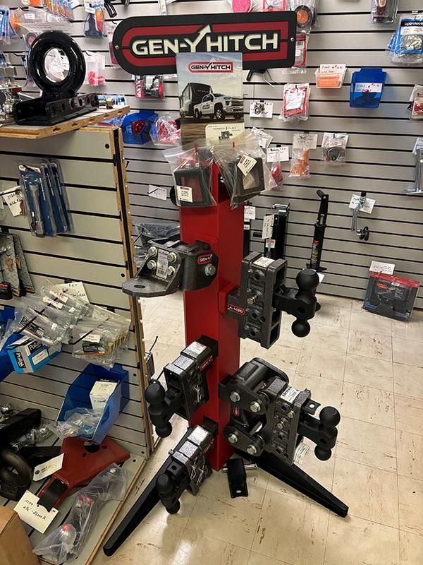 Display of Gen-Y Hitch products on a red, upright stand in a retail store setting. | Dave Muller Automotive & Trailer