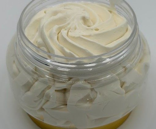 Whipped shea and mango body butter showing creamy texture inside clear jar