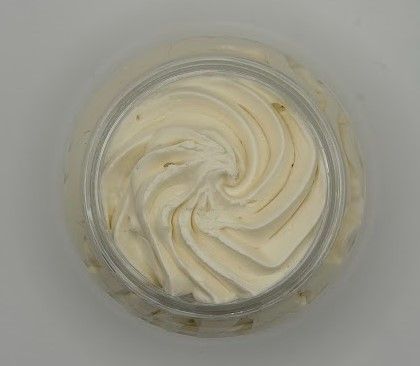 Whipped shea and mango body butter showing creamy texture inside clear jar