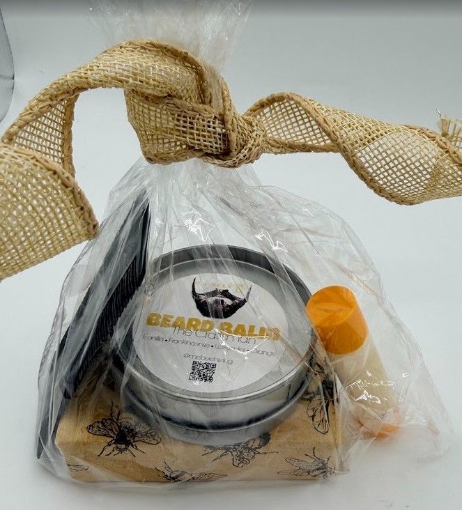 Men’s grooming gift set with beard balm, wooden comb, soap, and lip balm wrapped in clear packaging with burlap bow