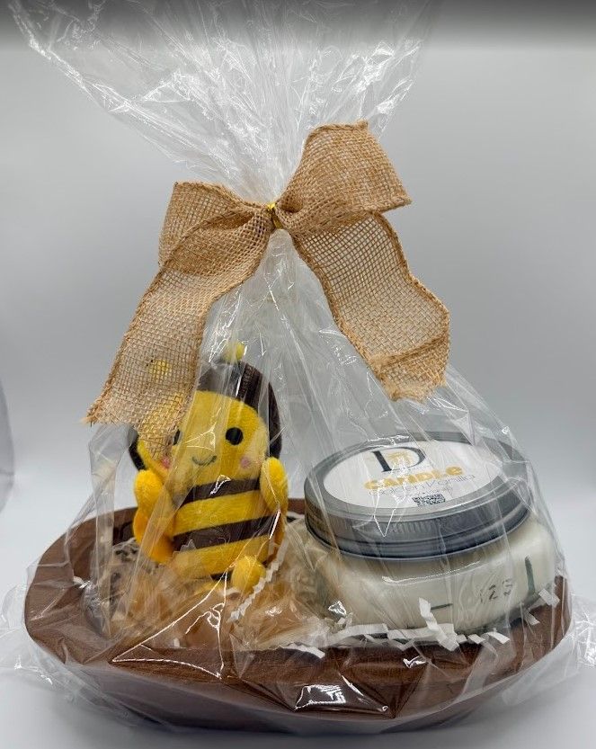 Hand-carved wooden dough bowl gift set containing a Honey Vanilla 8 oz mason-lid candle, a small plush bee keychain, and wrapped honey drops nestled in paper shred