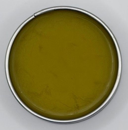 Handcrafted comfrey salve in reusable tin, showing green-gold herbal balm made with homegrown comfrey and beeswax
