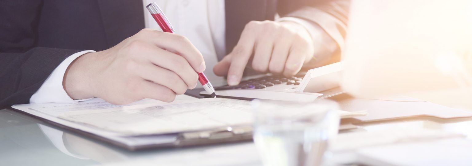 Man Using Pen and Calculator — Jacksonville Beach, FL — Tax Advantage