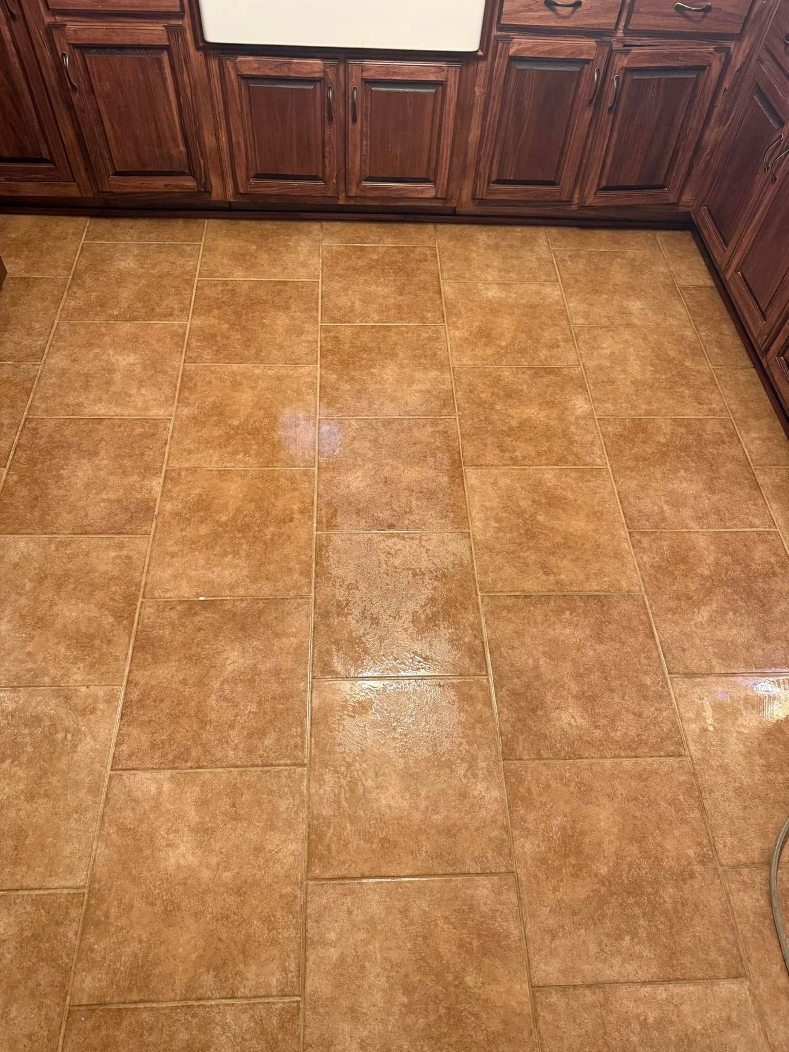 A kitchen with a tile floor and wooden cabinets.