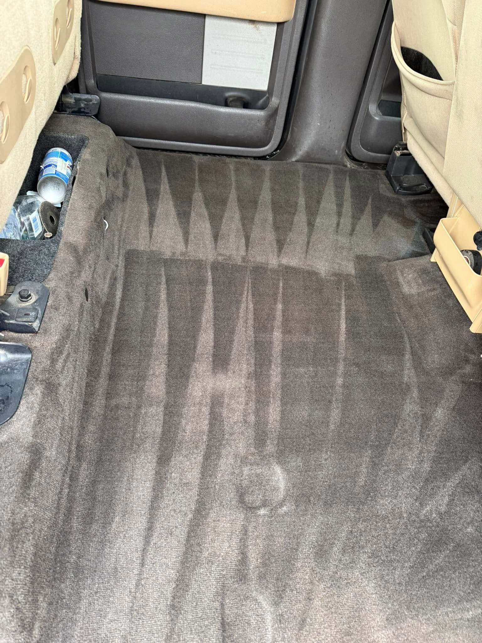 The inside of a car with a bottle of water in the back seat.