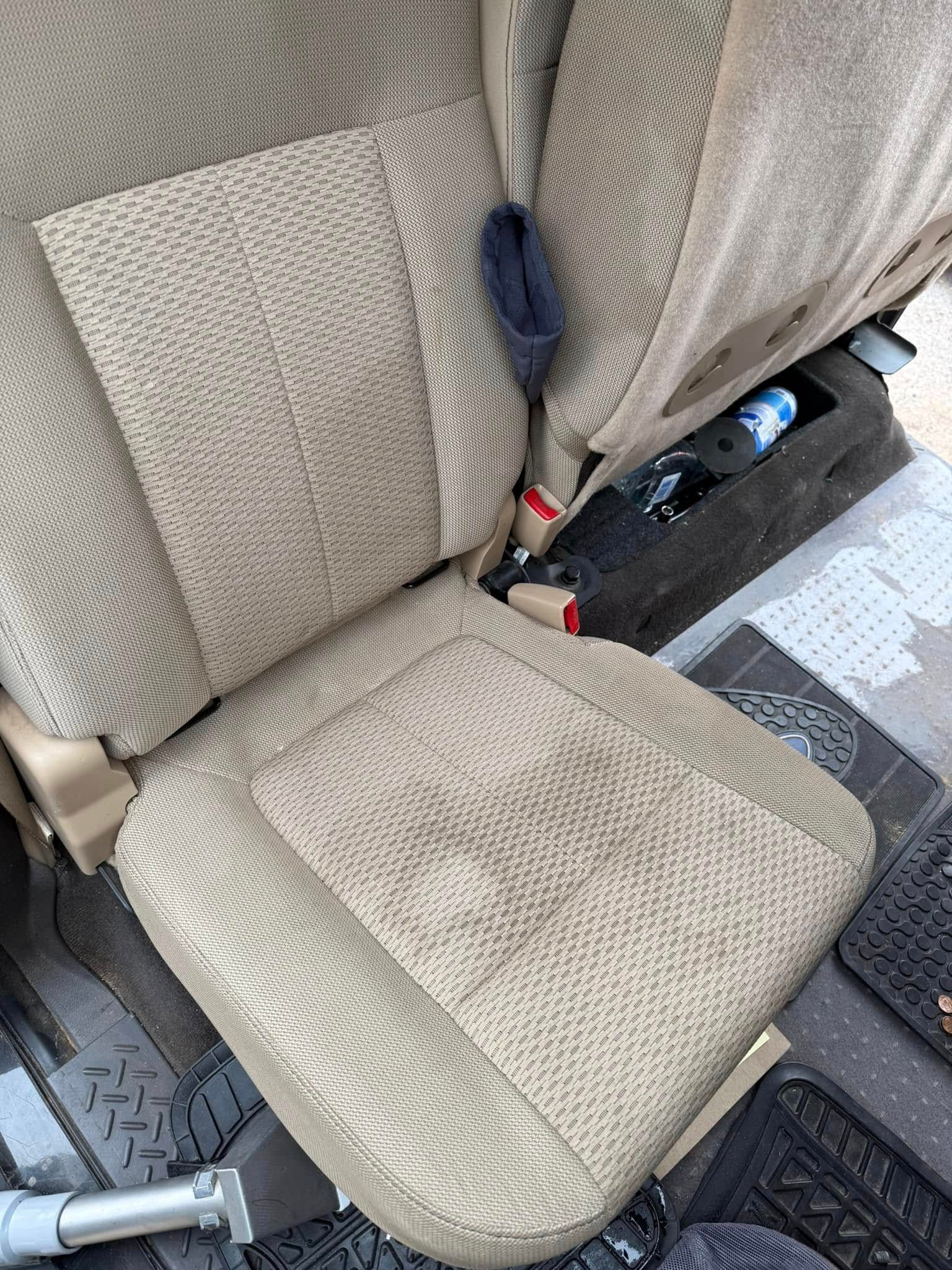 A close up of a car seat with a seat belt on it.