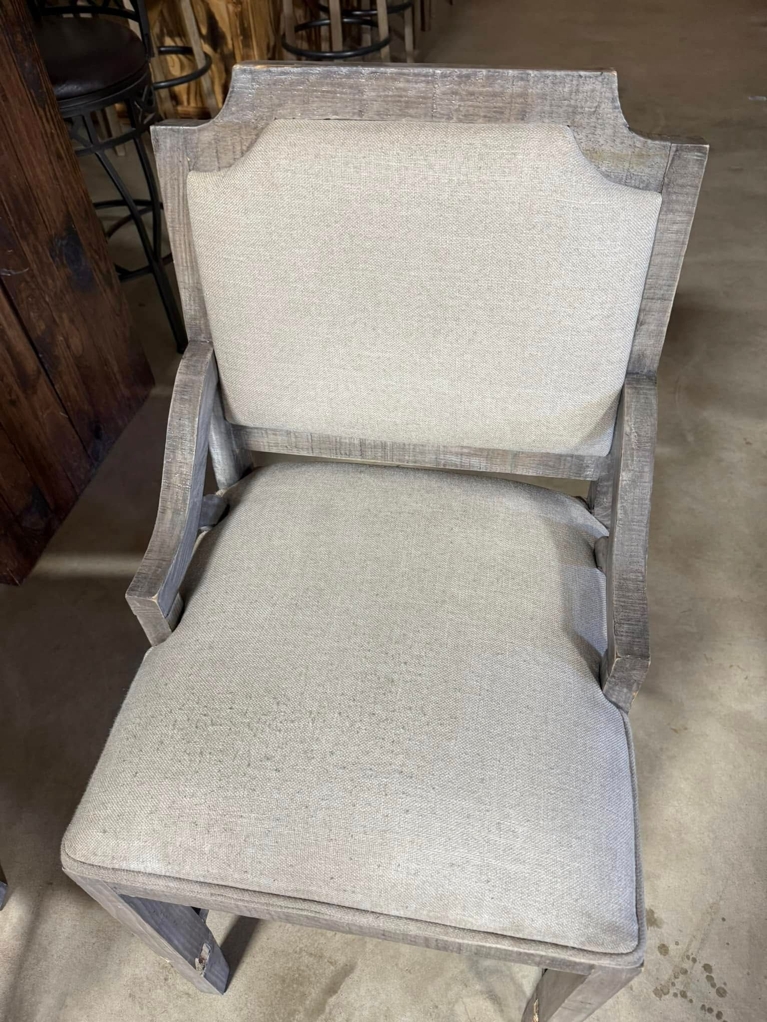 A chair and ottoman are sitting on a concrete floor.