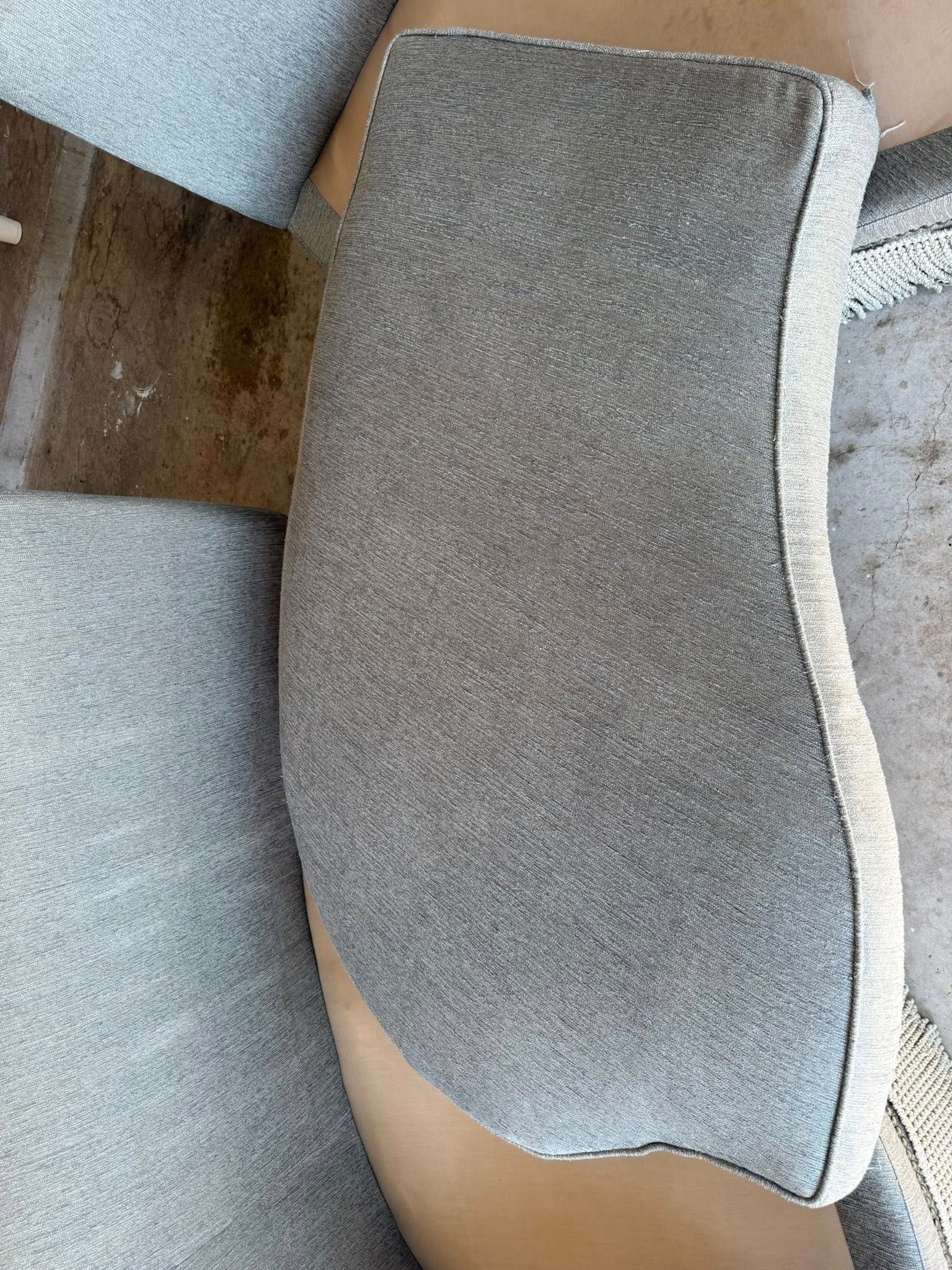 A woman is sitting on a couch wearing a pair of grey underwear.