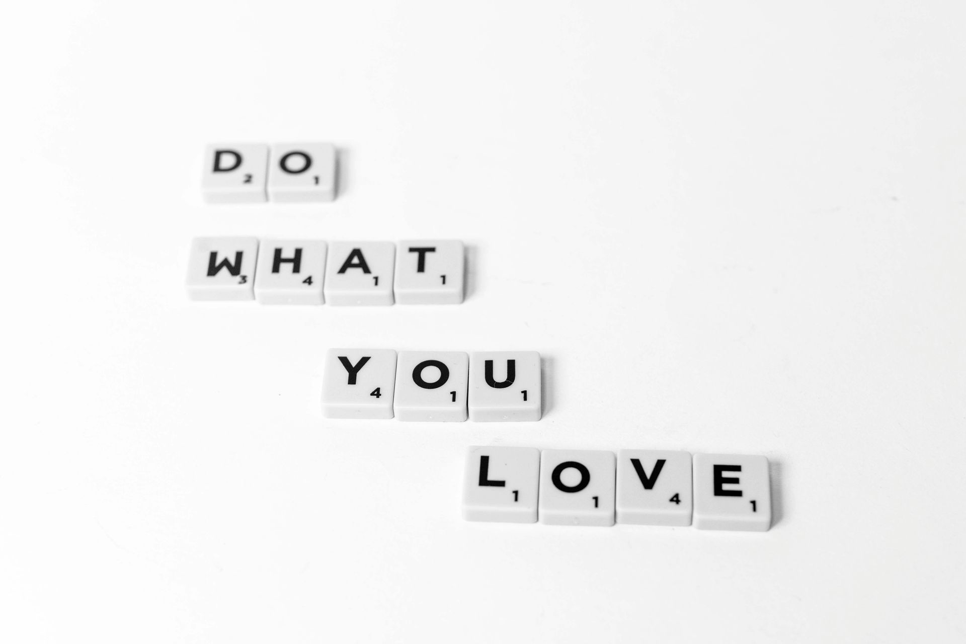 The words what you love are written in scrabble tiles on a white background.