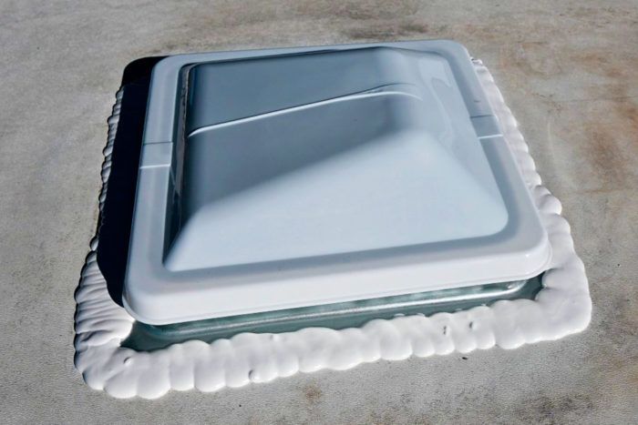 A white skylight sitting on top of a concrete surface