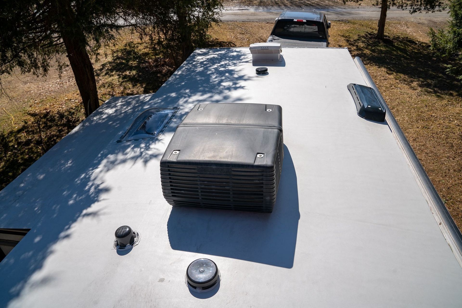 A roof of a rv with a fan on top of it.