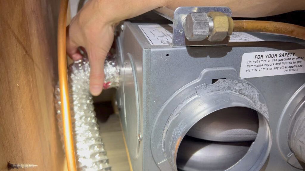 A person is fixing an air conditioner with a wrench.