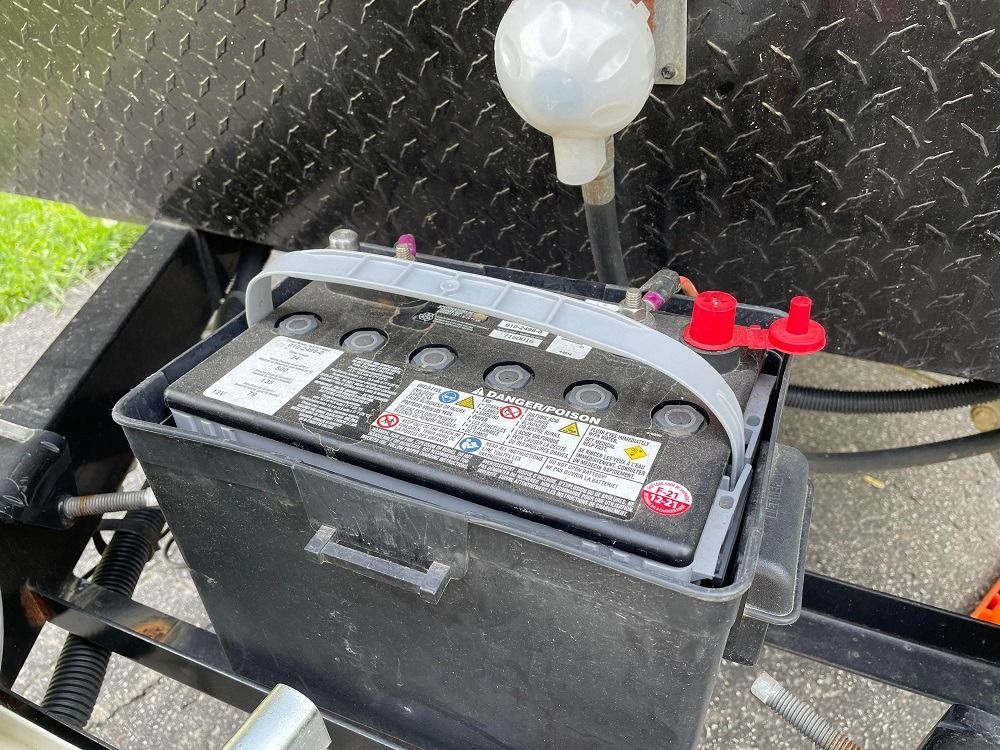 A black battery is sitting on top of a trailer.