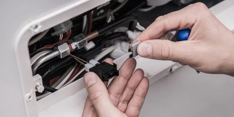 A person is fixing a light fixture with a screwdriver
