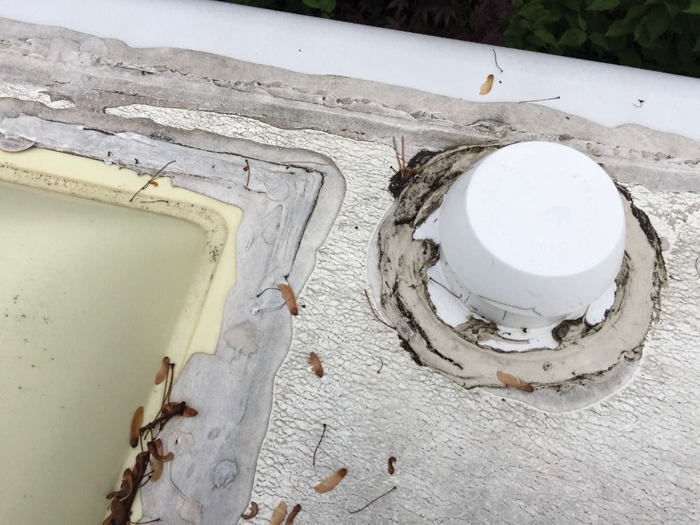 A white bucket is sitting on top of a concrete surface.