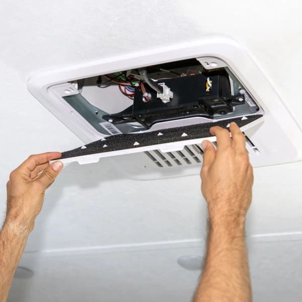 A person is working on the ceiling of a vehicle