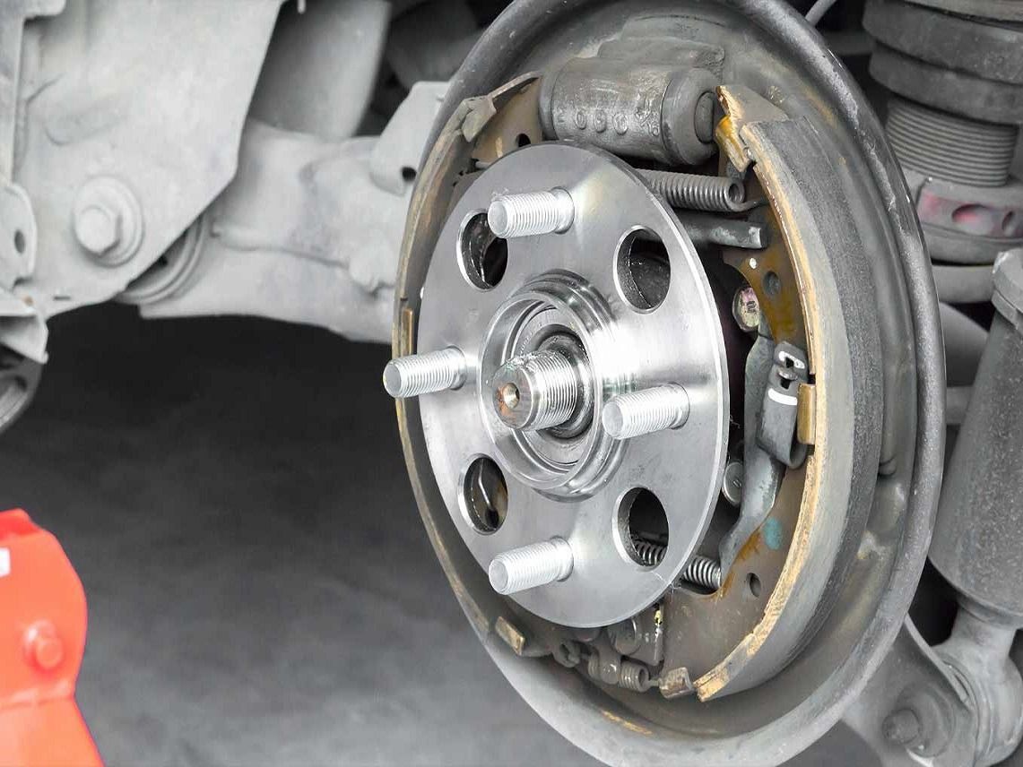 A person is measuring a piece of metal with a caliper