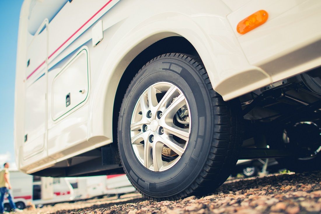 A truck with a flat tire on the side of the road.