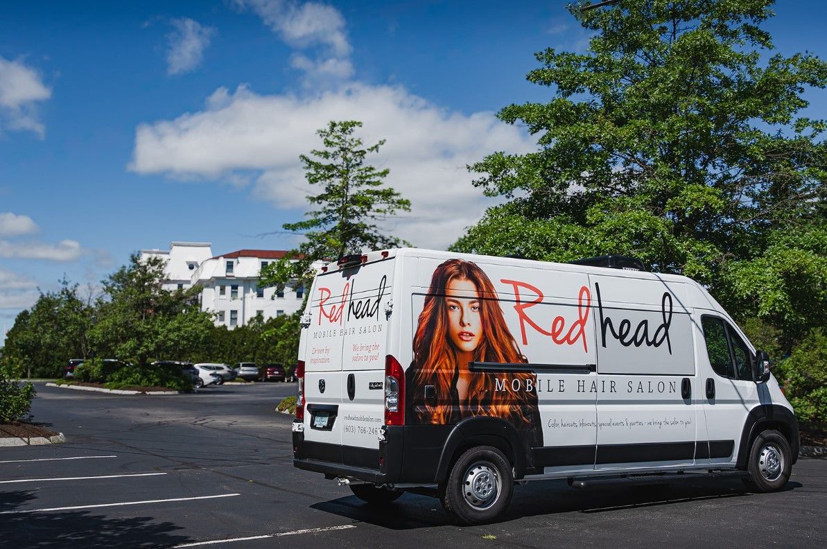 A white mobile salon parked near a client’s home.