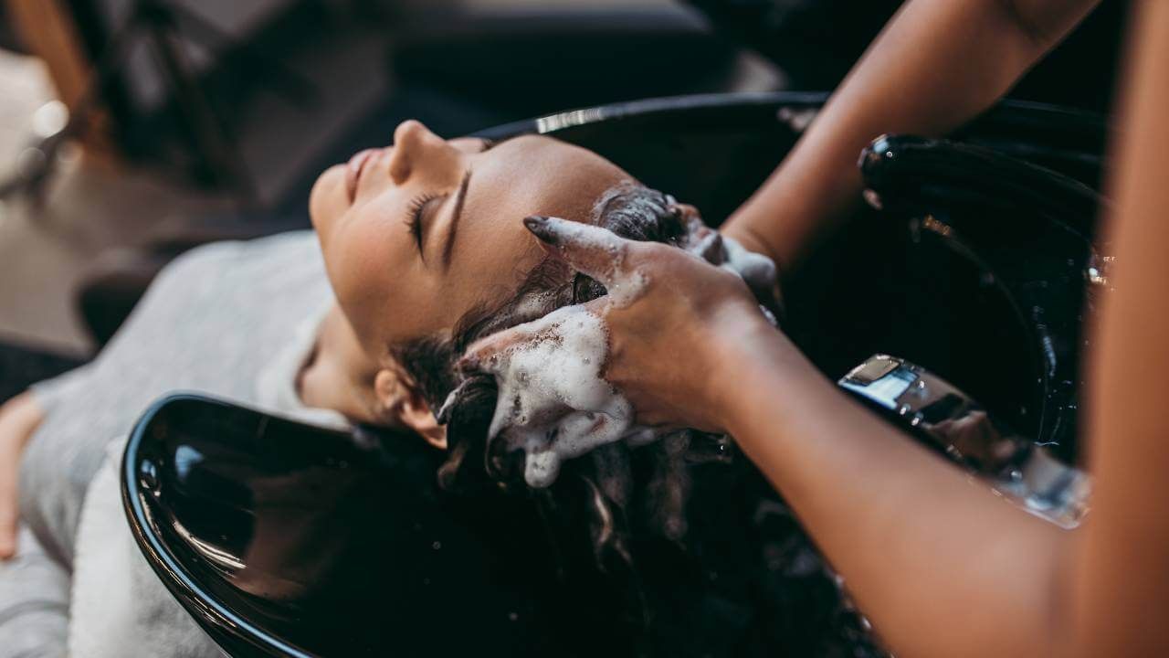 A woman enjoying a hair wash at a salon.